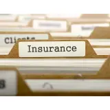 Cartella con etichetta "Insurance". Documenti organizzati per assicurazioni e franchigie, pronti per essere consultati.