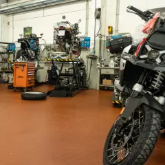 Officina moto con diverse moto in lavorazione. Chissà quanto tempo ci vuole per fare un tagliando moto in un posto così attrezzato.