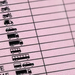 Dettaglio di una patente di guida europea che mostra le diverse categorie di veicoli autorizzati, dalle moto ai camion, per coprire tutte le patenti di guida.