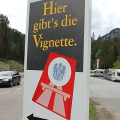 Cartello stradale "Qui si vende la Vignette" vicino al confine e61 Slovenia. Veicoli in transito e campeggiatori.
