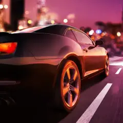 Auto sportiva di notte in città. Pensando a quando si paga il superbollo, la strada si illumina di luci sfocate.