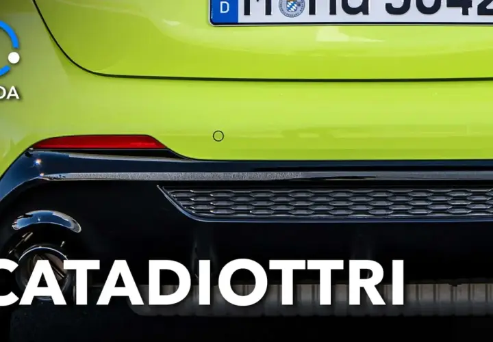 Guida: cosa sono i catadiottri? Riflettori rossi posteriori su un'auto verde brillante, essenziali per la sicurezza.