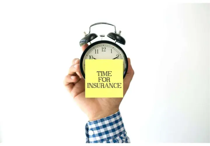 Mano che tiene una sveglia con un post-it giallo con scritto "TIME FOR INSURANCE". Quanto tempo ho per pagare l'assicurazione?