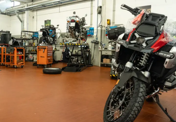 Officina moto con diverse moto in lavorazione. Chissà quanto tempo ci vuole per fare un tagliando moto in un posto così attrezzato.