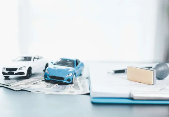 Modellini di auto su banconote, con penna e timbro su documenti. Pensando a disdetta assicurazione auto quanto tempo prima.