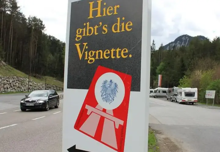 Cartello stradale "Qui si vende la Vignette" vicino al confine e61 Slovenia. Veicoli in transito e campeggiatori.