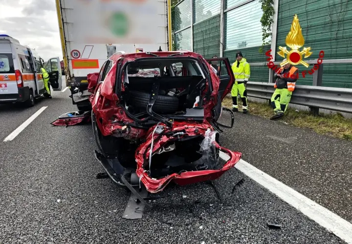 Un'auto rossa gravemente danneggiata dopo un incidente. Sul posto un'ambulanza e i vigili del fuoco. Ecco cosa fare in caso di incidente.