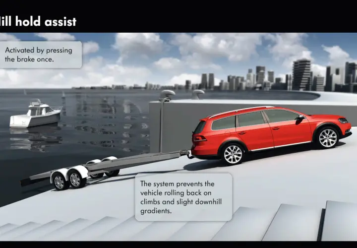 Auto rossa con rimorchio su una rampa. Il hill holder cos'è? Un sistema che impedisce all'auto di arretrare in salita.