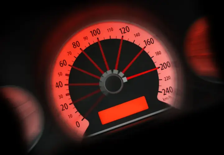 Tachimetro rosso acceso, l'ago indica circa 100 km/h. Potrebbe essere una multa per eccesso velocità sotto 10 km/h.