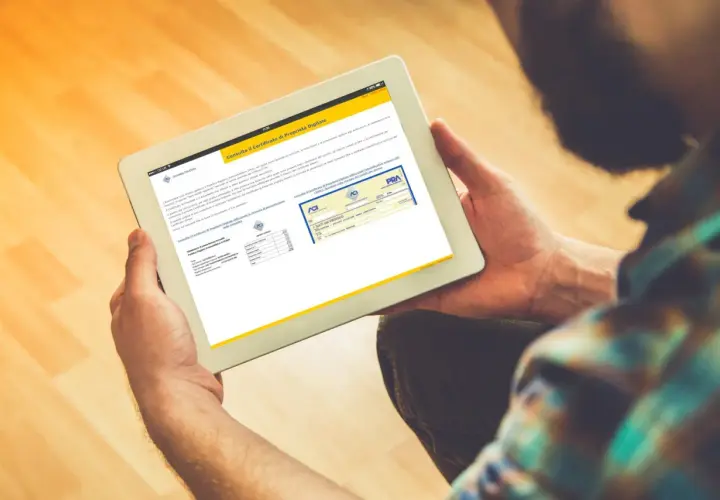 Uomo consulta su tablet il certificato di proprietà digitale, un documento essenziale per la gestione dei veicoli.