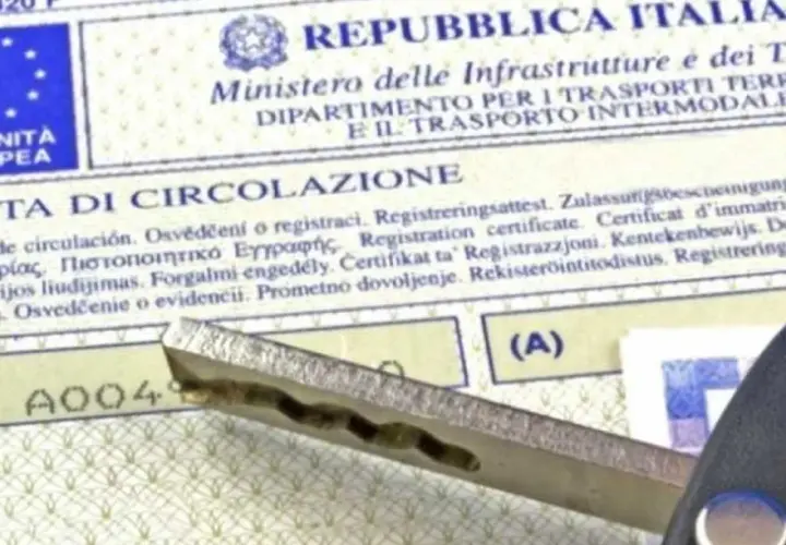 Chiave dell'auto appoggiata sul certificato di circolazione, un documento essenziale per la mobilità.