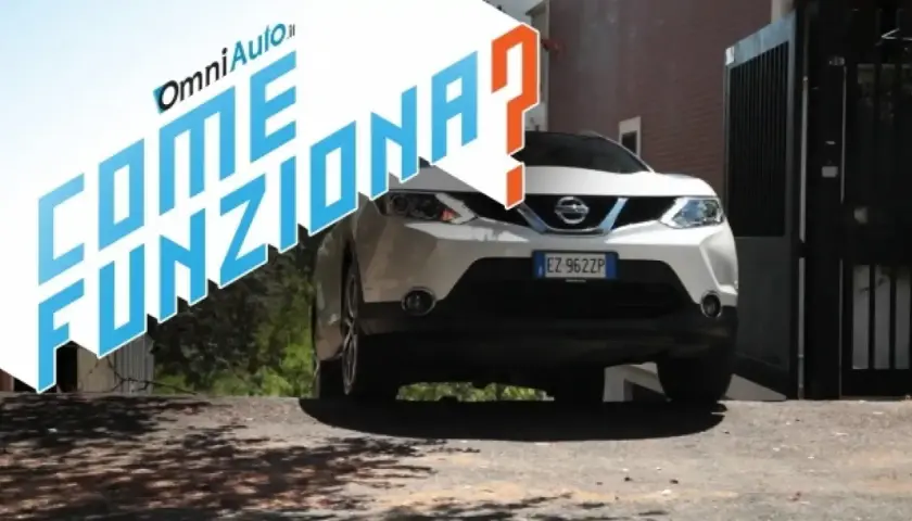 Auto bianca con scritta "Come funziona?". Spiegazione del sistema hill holder per partire in salita.