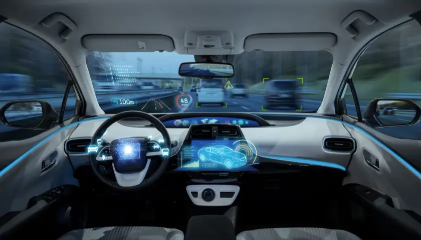Interno di un'auto con display olografico che mostra dati di guida assistita, velocità e navigazione.