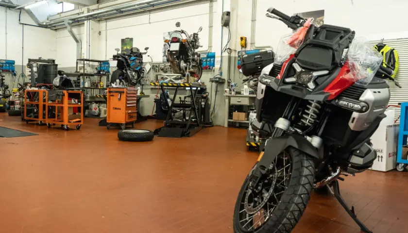 Officina moto con diverse moto in lavorazione. Chissà quanto tempo ci vuole per fare un tagliando moto in un posto così attrezzato.