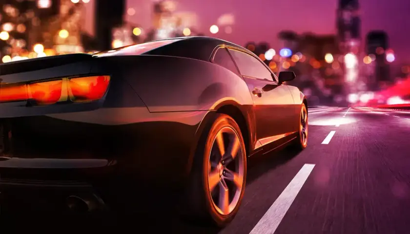 Auto sportiva di notte in città. Pensando a quando si paga il superbollo, la strada si illumina di luci sfocate.