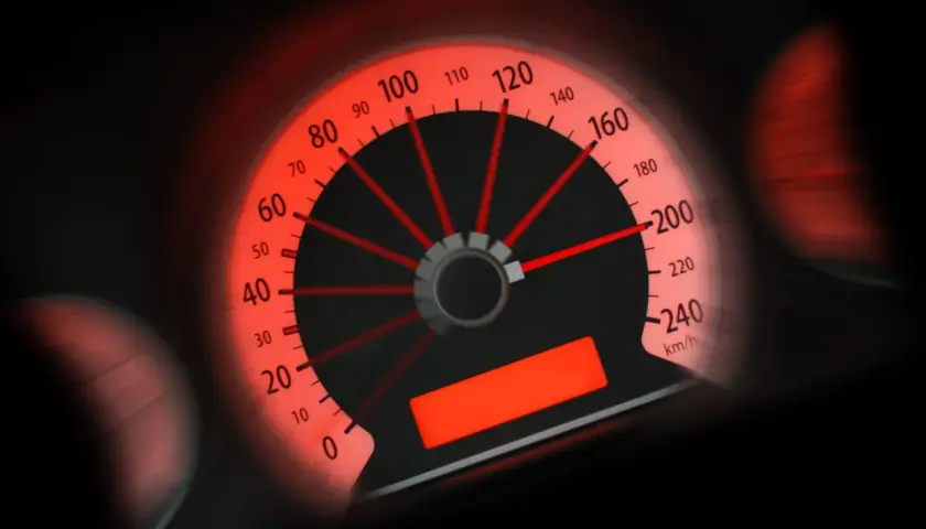 Tachimetro rosso acceso, l'ago indica circa 100 km/h. Potrebbe essere una multa per eccesso velocità sotto 10 km/h.