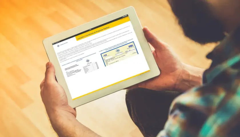Uomo consulta su tablet il certificato di proprietà digitale, un documento essenziale per la gestione dei veicoli.