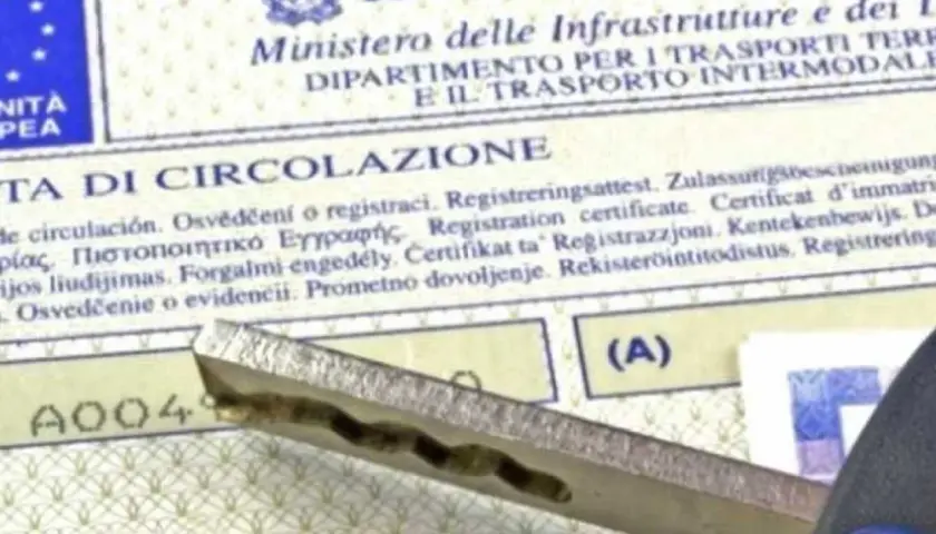 Chiave dell'auto appoggiata sul certificato di circolazione, un documento essenziale per la mobilità.