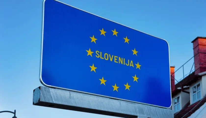 Cartello blu con stelle dorate dell'UE e la scritta "SLOVENIJA". Benvenuti sulle autostrade slovene!