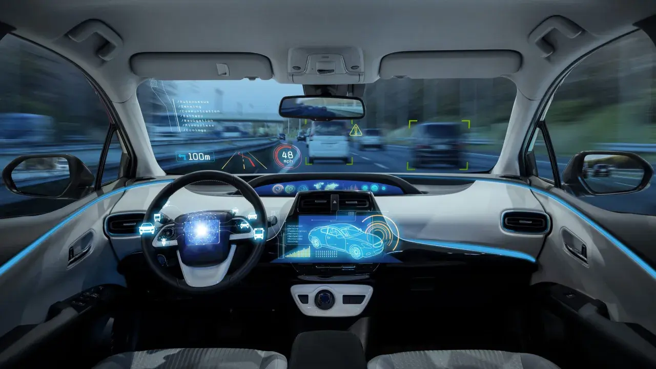 Interno di un'auto con display olografico che mostra dati di guida assistita, velocità e navigazione.