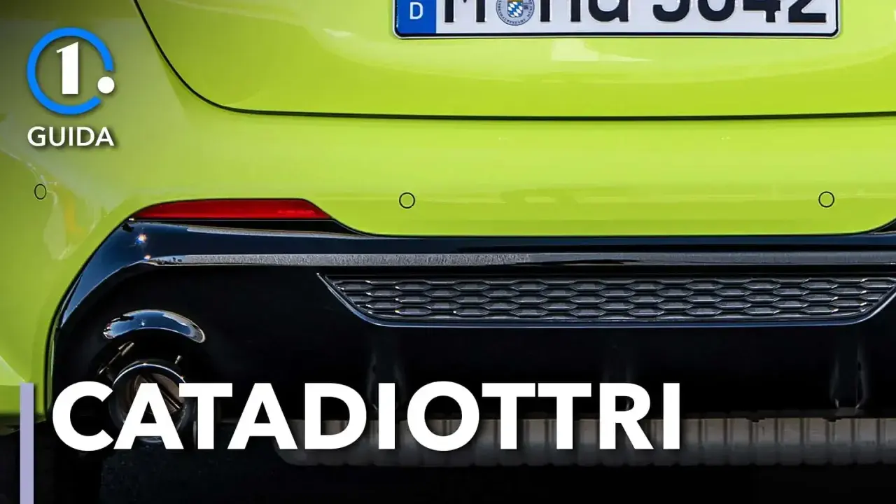 Guida: cosa sono i catadiottri? Riflettori rossi posteriori su un'auto verde brillante, essenziali per la sicurezza.