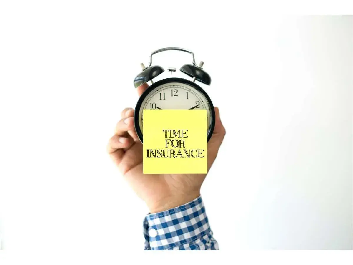 Mano che tiene una sveglia con un post-it giallo con scritto "TIME FOR INSURANCE". Quanto tempo ho per pagare l'assicurazione?