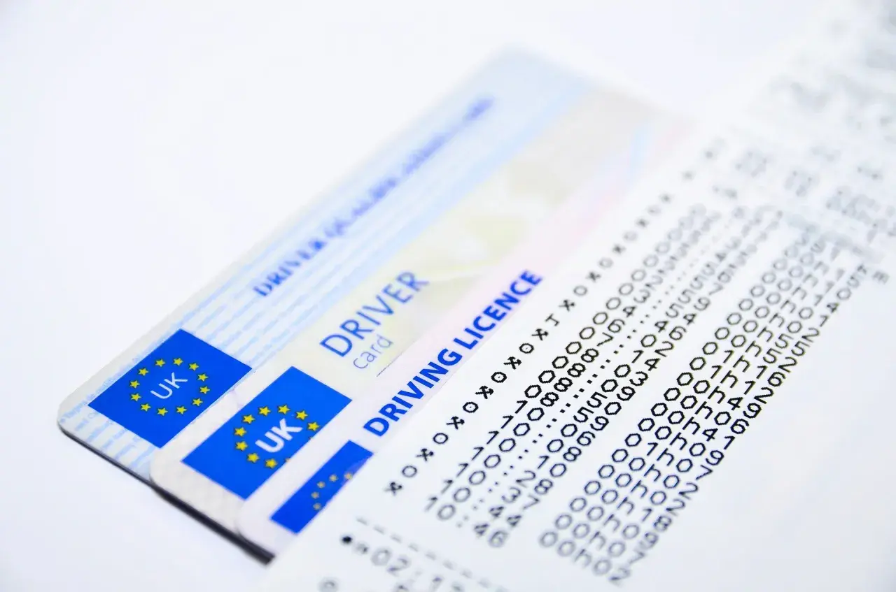 Patente di guida UK e un foglio con dati, forse una notifica tardiva ordinanza sospensione patente.