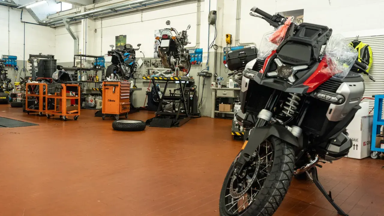 Officina moto con diverse moto in lavorazione. Chissà quanto tempo ci vuole per fare un tagliando moto in un posto così attrezzato.