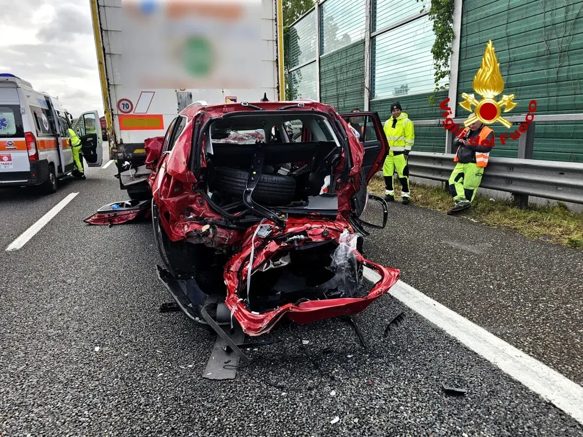 Un'auto rossa gravemente danneggiata dopo un incidente. Sul posto un'ambulanza e i vigili del fuoco. Ecco cosa fare in caso di incidente.