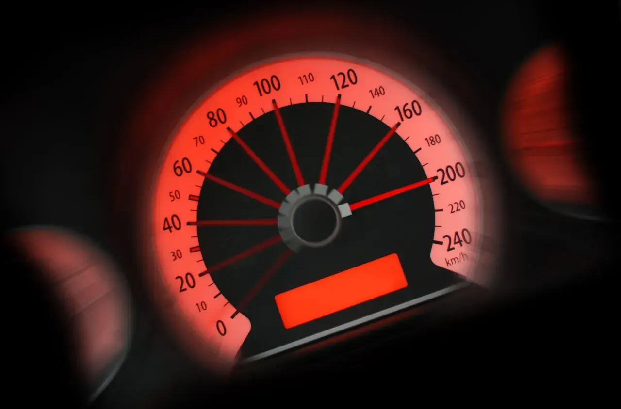 Tachimetro rosso acceso, l'ago indica circa 100 km/h. Potrebbe essere una multa per eccesso velocità sotto 10 km/h.