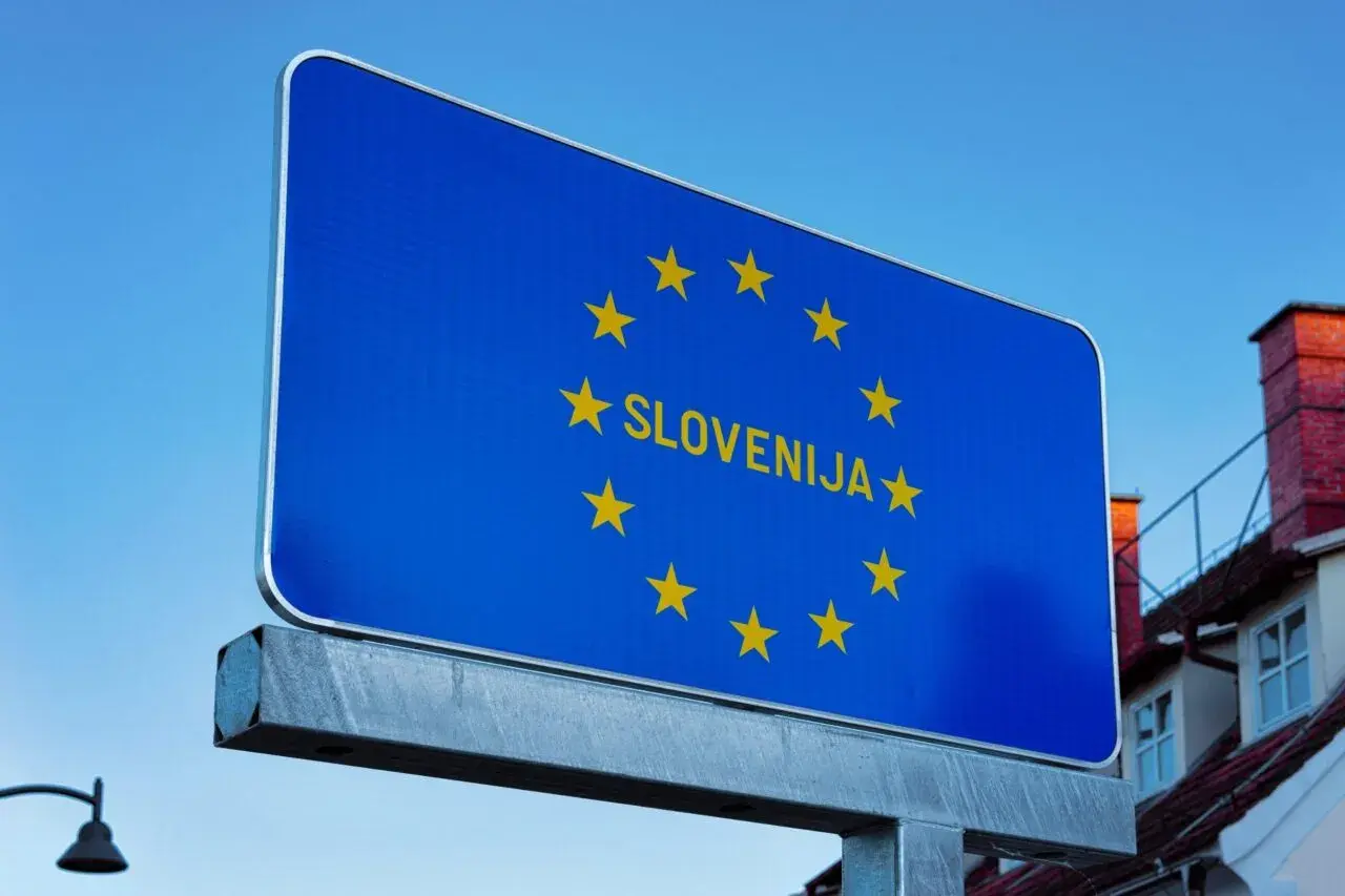 Cartello blu con stelle dorate dell'UE e la scritta "SLOVENIJA". Benvenuti sulle autostrade slovene!