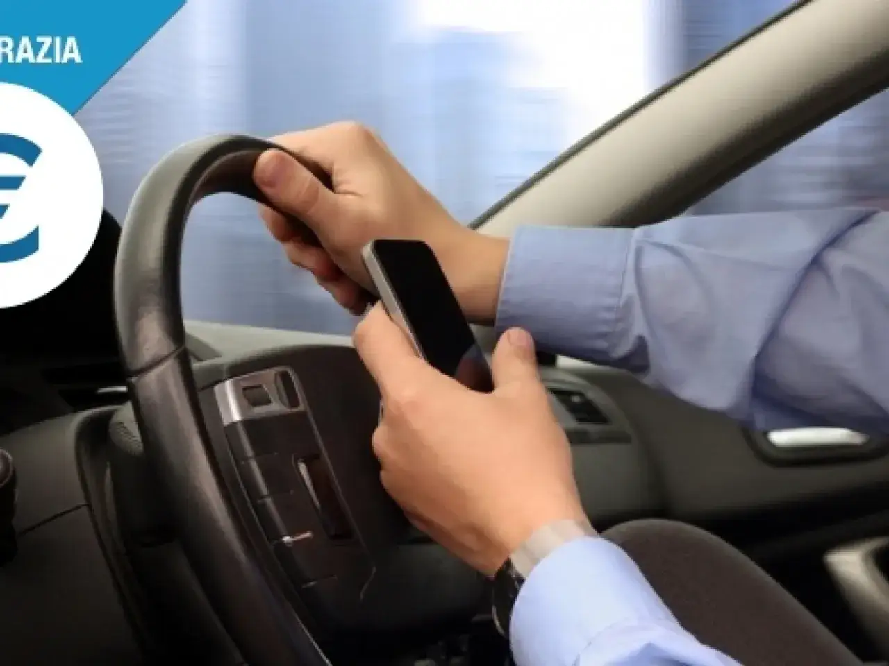Mani al volante, ma una è impegnata con il cellulare. Guida con cellulare: un gesto pericoloso che può costare caro.