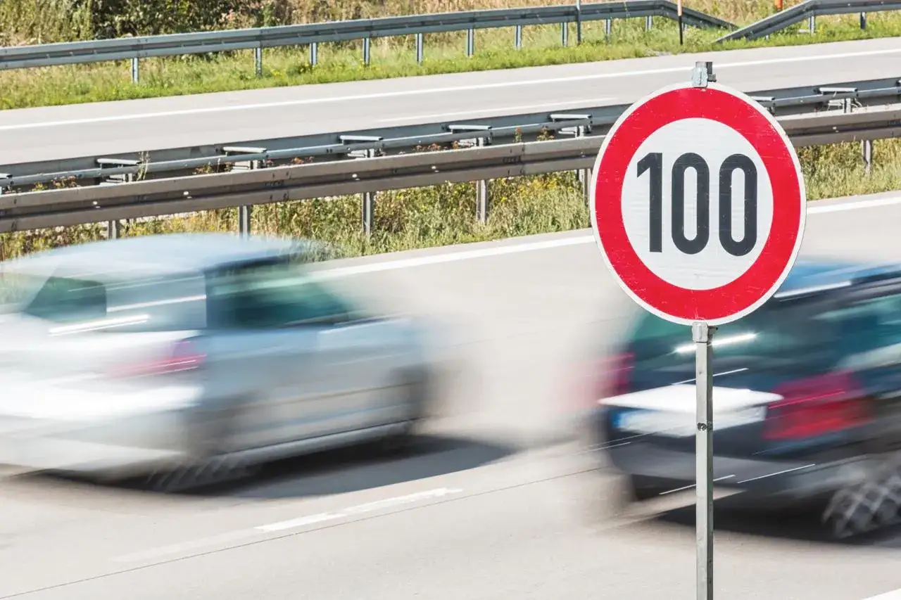 Segnale di limite di velocit&agrave; 100 km/h su autostrada. Attenzione alla sospensione patente velocit&agrave;, le auto sfrecciano.