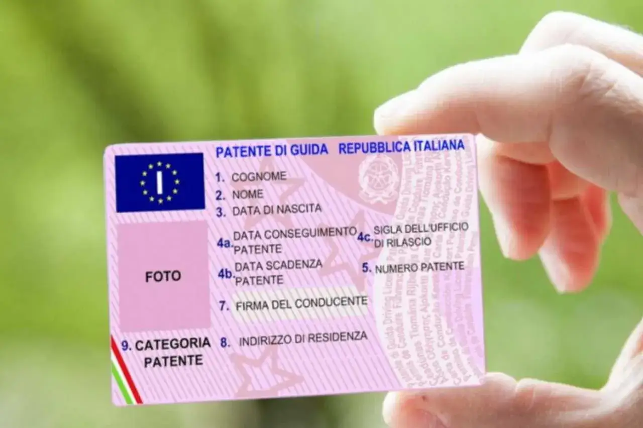 Una mano tiene una patente di guida italiana, un documento essenziale per guidare. Quando la patente non è duplicabile, la perdita o il furto diventano un problema serio.