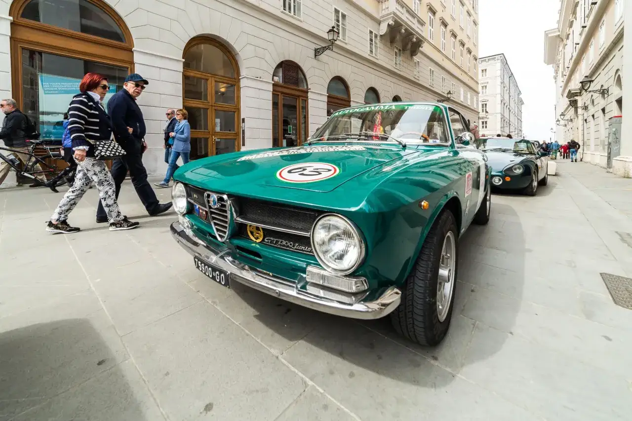 Un'Alfa Romeo verde brillante, con il numero 63 sul cofano, pronta per un evento. Il foglio complementare sul parabrezza indica