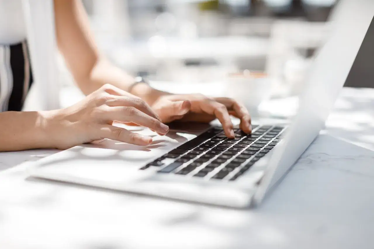 Mani che digitano su un laptop, forse per richiedere l'accesso agli atti assicurazione.